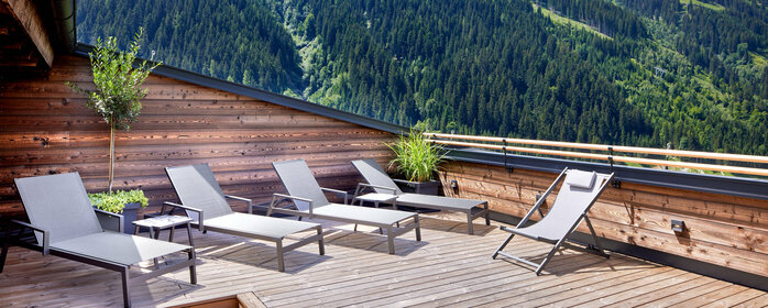 Sonnenliegen auf Dachterrasse mit Panoramaausblick auf Berge