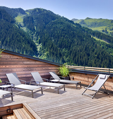 Sonnenliegen auf Dachterrasse mit Panoramaausblick auf Berge