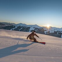 Skifahrer vor untergehender Sonne