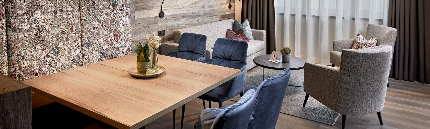 Esstisch mit Sitzbank und Stühlen vor Sofa mit 2 Sesseln im Mei.Platz Appartement