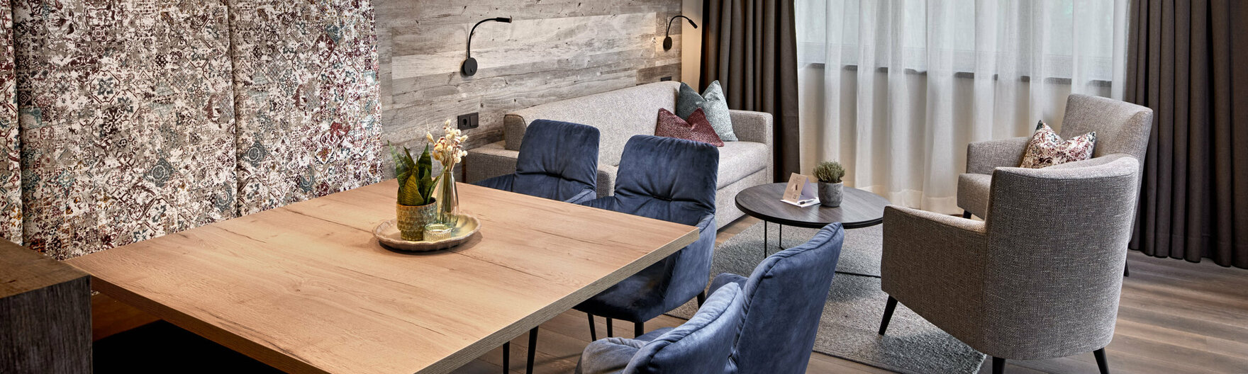 Esstisch mit Sitzbank und Stühlen vor Sofa mit 2 Sesseln im Mei.Platz Appartement