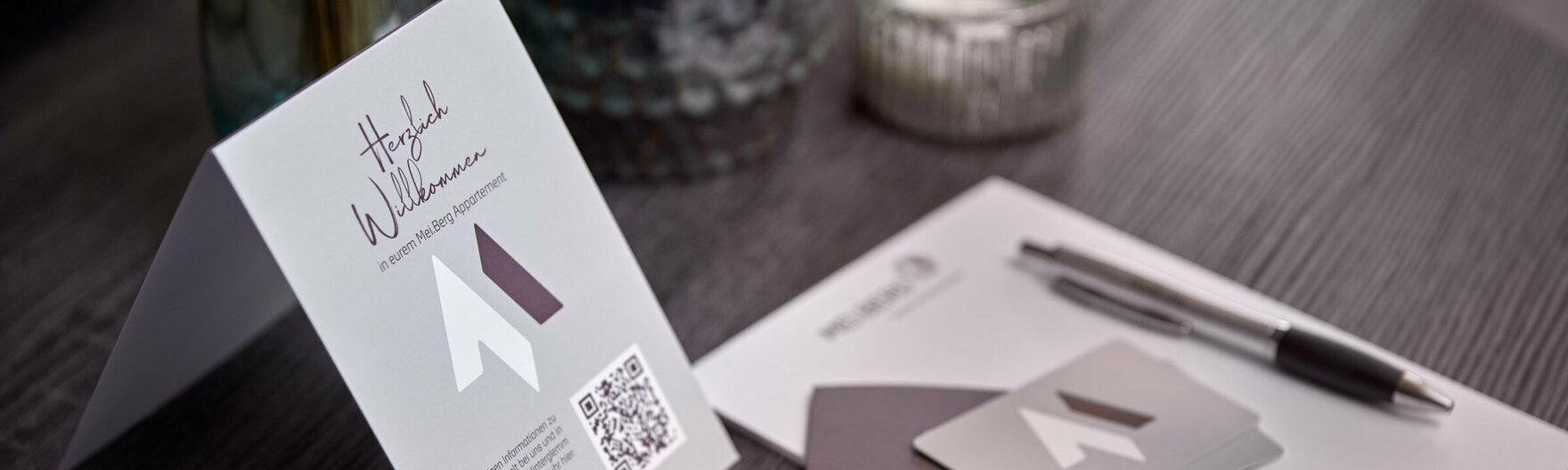 Mei.Berg Infomaterial auf Wohnzimmertisch mit Blumen