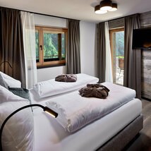 Schlafzimmer mit Fernseher, Fenster und Balkonzugang im Mei.Platz Appartement