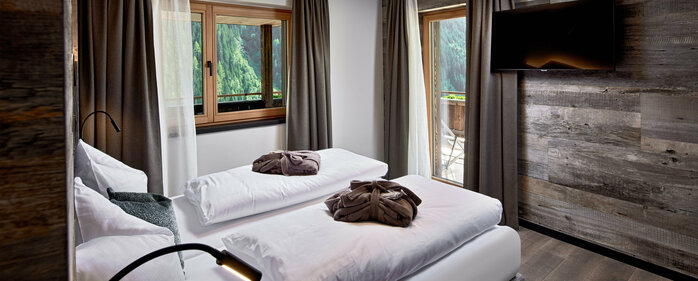 Schlafzimmer mit Fernseher, Fenster und Balkonzugang im Mei.Platz Appartement