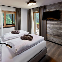 Schlafzimmer mit Fernseher, Fenster und Balkonzugang im Mei.Platz Appartement