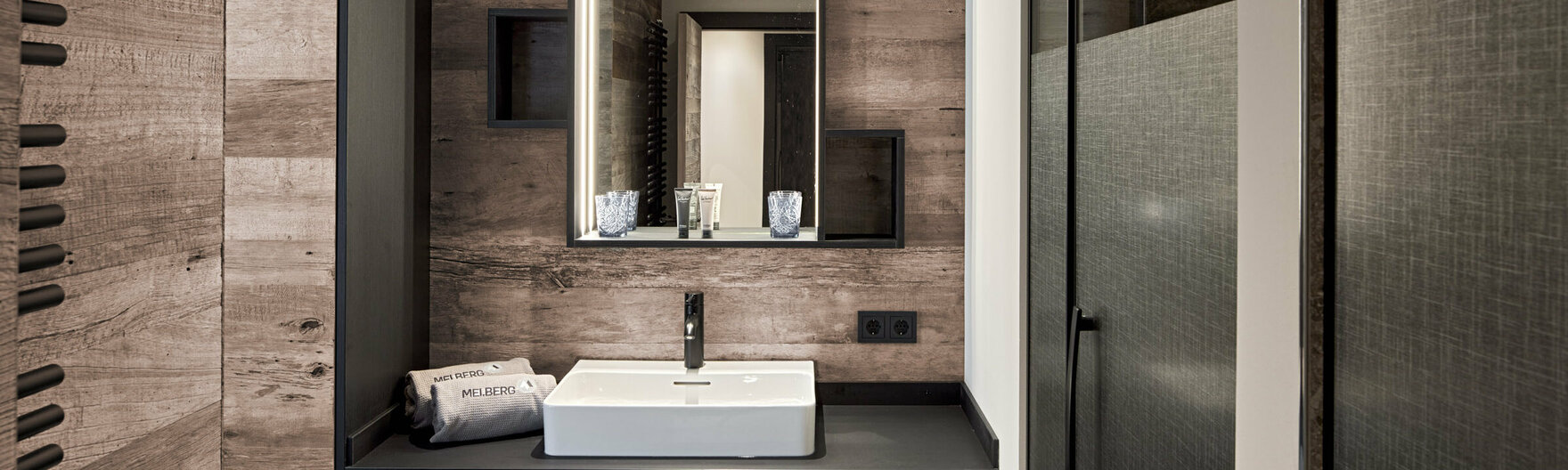 Badezimmer mit Waschbecken und Dusche im Mei.Platz Appartement