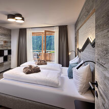 Schlafzimmer mit Doppelbett, Fernseher und offener Balkontür im Mei.Rückzug Appartement