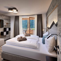 Schlafzimmer mit Doppelbett, Fernseher und offener Balkontür im Mei.Rückzug Appartement