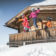 Familie in Skiausrüstung auf Berghütte