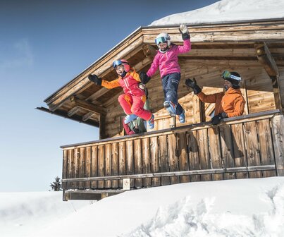Familie in Skiausrüstung auf Berghütte