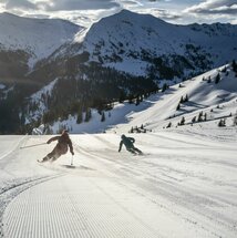 Zwei Skifahrer auf der frisch präparierten Piste