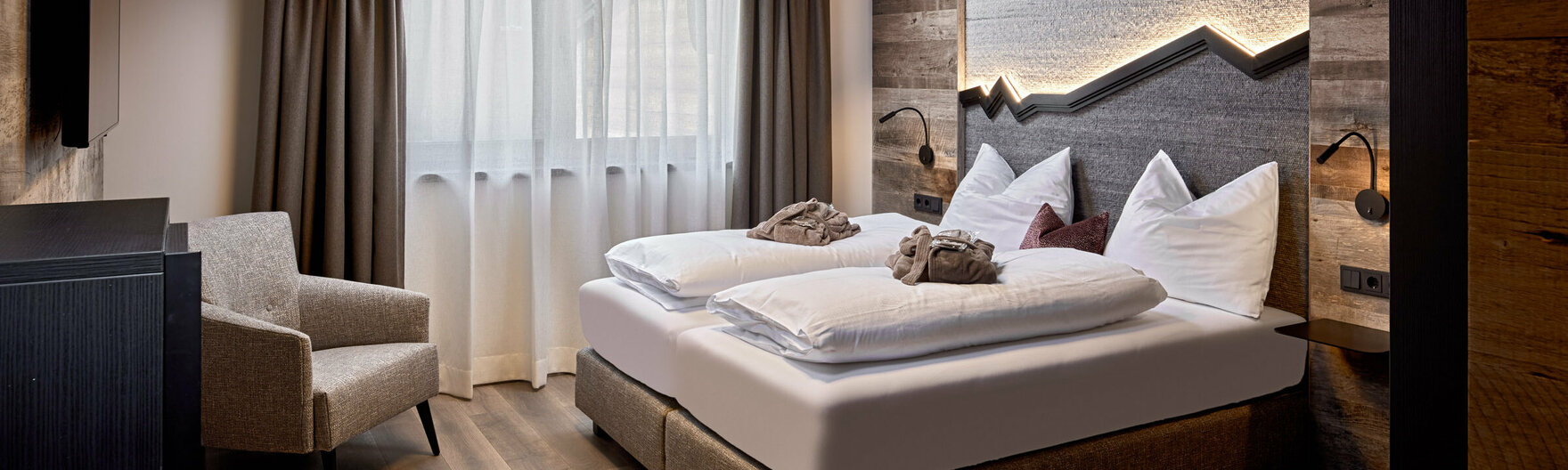 Schlafzimmer mit Doppelbett, Sessel und Fernseher im Mei.Penthouse