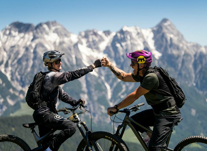 Zwei Mountainbiker vor Gipfelpanorama