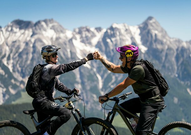 Zwei Mountainbiker vor Gipfelpanorama