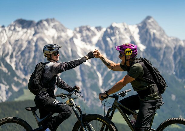 Zwei Mountainbiker vor Gipfelpanorama