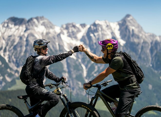 Zwei Mountainbiker vor Gipfelpanorama