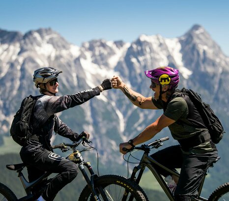 Zwei Mountainbiker vor Gipfelpanorama