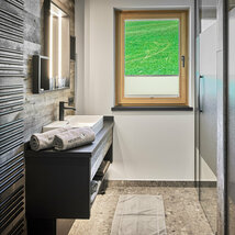 Badezimmer mit Waschbecken, Dusche und Fenster im Mei.Penthouse