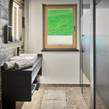 Badezimmer mit Waschbecken, Dusche und Fenster im Mei.Penthouse