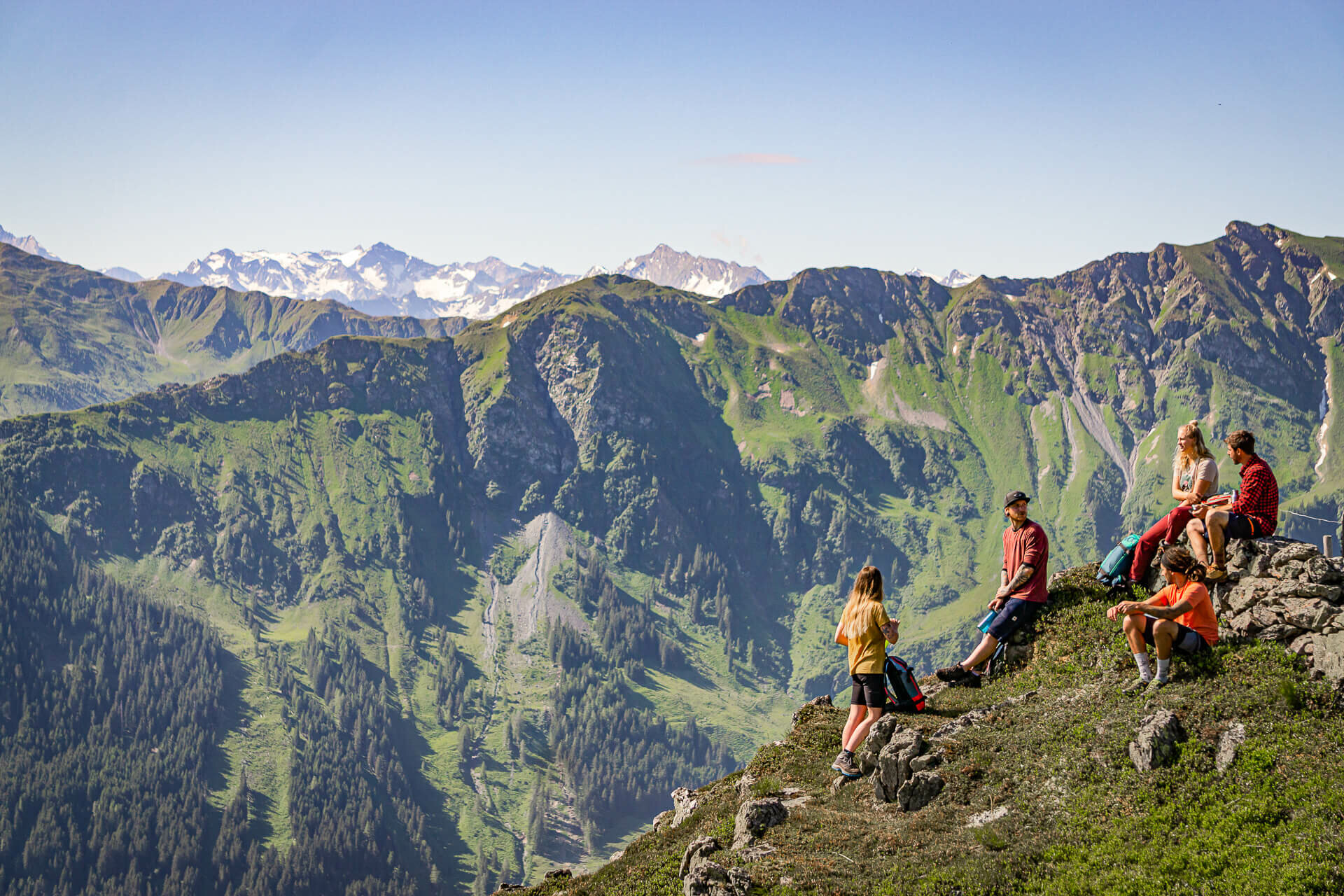 Wandergruppe bei Rast vor Gebirgspanorama