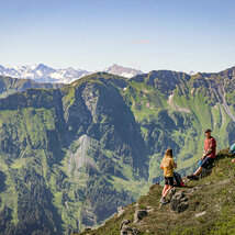 Wandergruppe bei Rast vor Gebirgspanorama