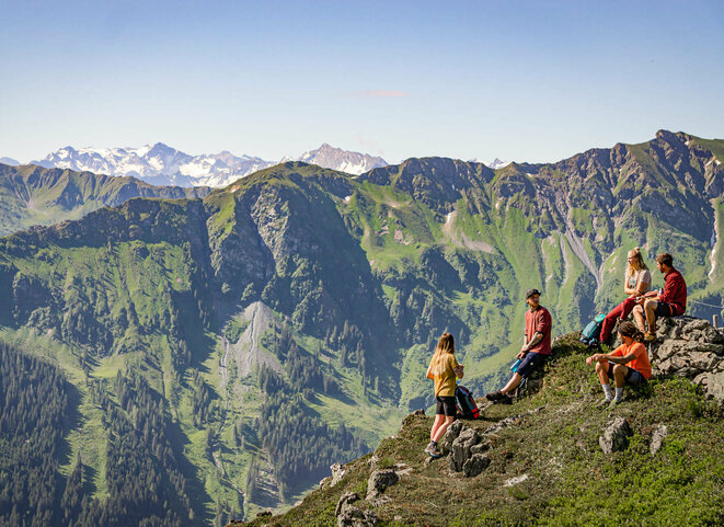 Wandergruppe bei Rast vor Gebirgspanorama