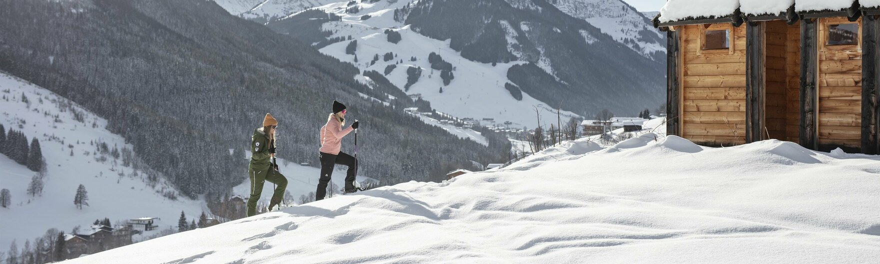 Paar beim Schneeschuhwandern auf dem Weg zur Hütte
