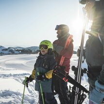 Familie mit Skiausrüstung am Berg