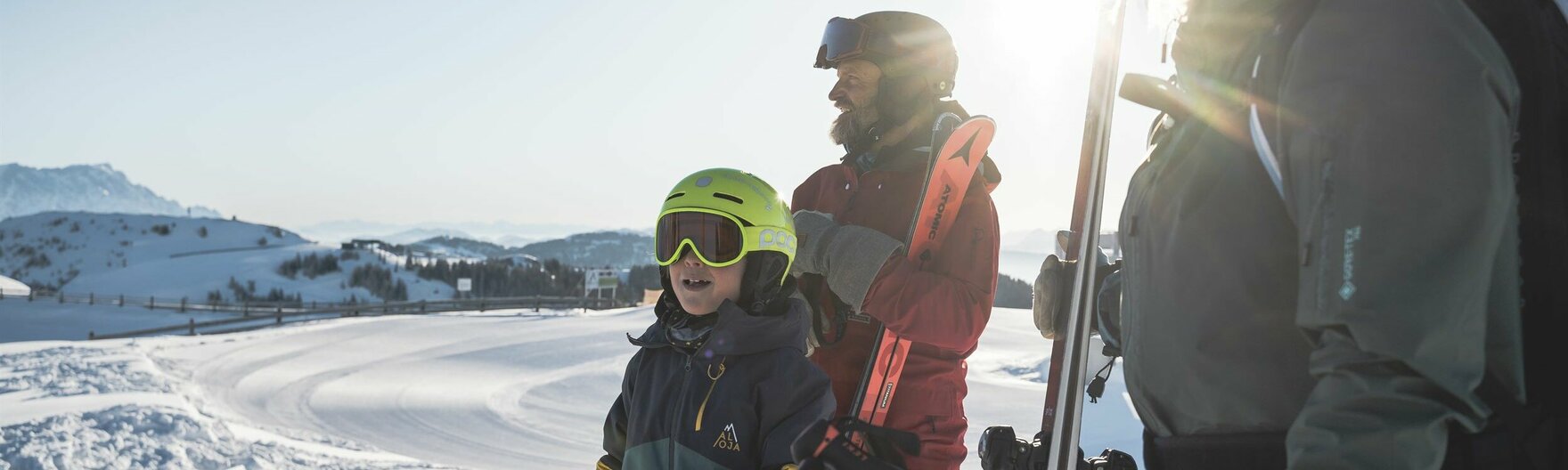 Familie mit Skiausrüstung am Berg