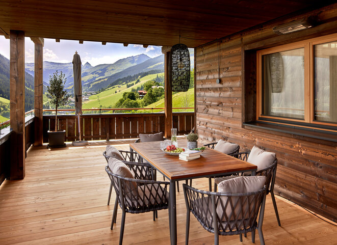 Großer Esstisch mit 6 Stühlen auf dem Balkon mit Ausblick auf Talkessel