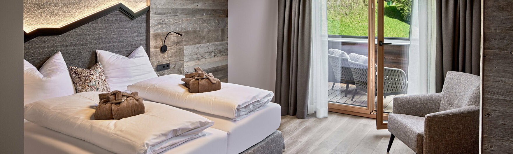 Schlazimmer mit Doppelbett, Sessel und Balkonzugang im Mei.Penthouse