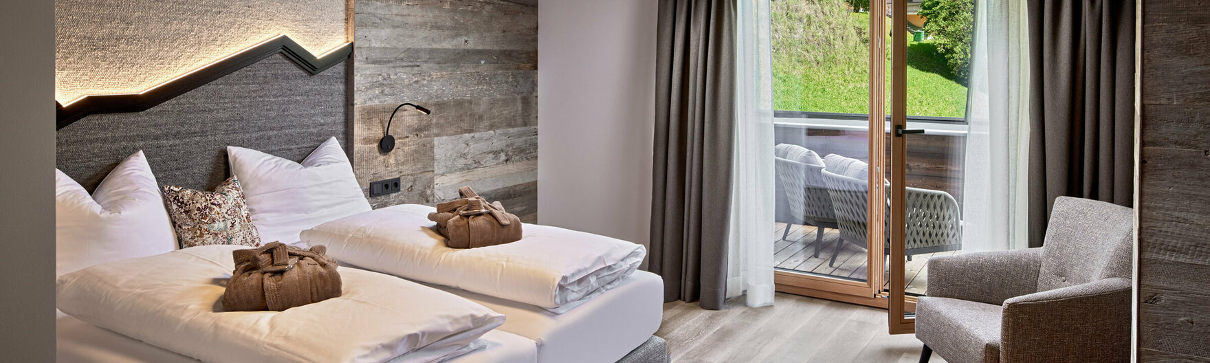 Schlazimmer mit Doppelbett, Sessel und Balkonzugang im Mei.Penthouse
