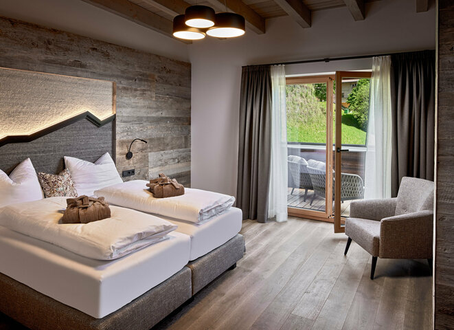 Schlazimmer mit Doppelbett, Sessel und Balkonzugang im Mei.Penthouse