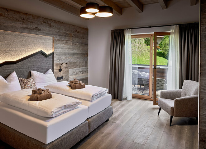 Schlazimmer mit Doppelbett, Sessel und Balkonzugang im Mei.Penthouse