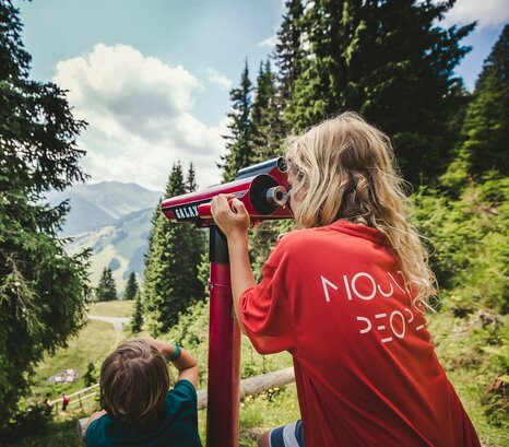 Zwei Kinder am Berg mit Aussichtsfernrohr