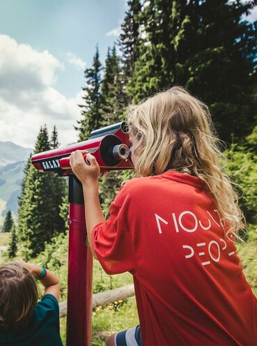 Zwei Kinder am Berg mit Aussichtsfernrohr