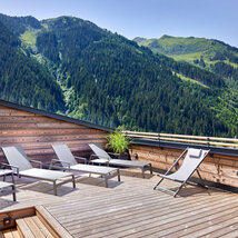 Sonnenliegen auf Dachterrasse mit Panoramaausblick auf Berge