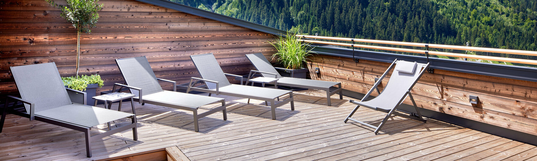Sonnenliegen auf Dachterrasse mit Panoramaausblick auf Berge