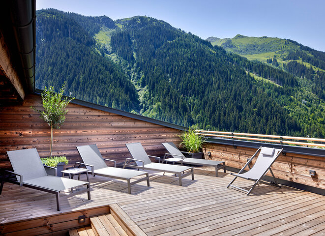 Sonnenliegen auf Dachterrasse mit Panoramaausblick auf Berge